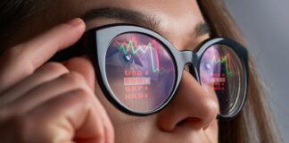 Kursy walut i wykresy odbijające się w okularach kobiety
