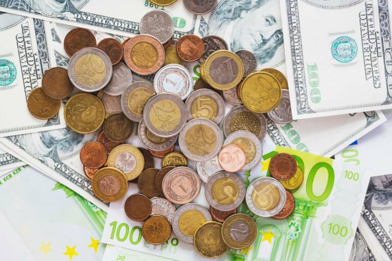 Monety PLN rozrzucone po banknotach EUR i USD