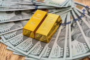 Sztabki złota leżące na dolarach