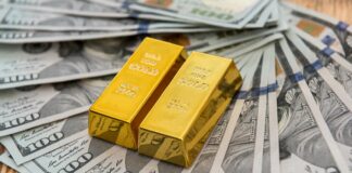 Sztabki złota leżące na dolarach