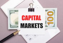 Napis "rynki kapitałowe", banknot, kalkulator i długopis