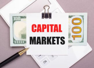 Napis "rynki kapitałowe", banknot, kalkulator i długopis