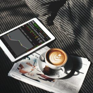 Kawa, gazeta i platforma tradingowa na tablecie